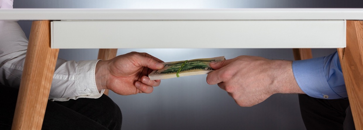 Handen schudden boven tafel en geld geven onder tafel. Fraude